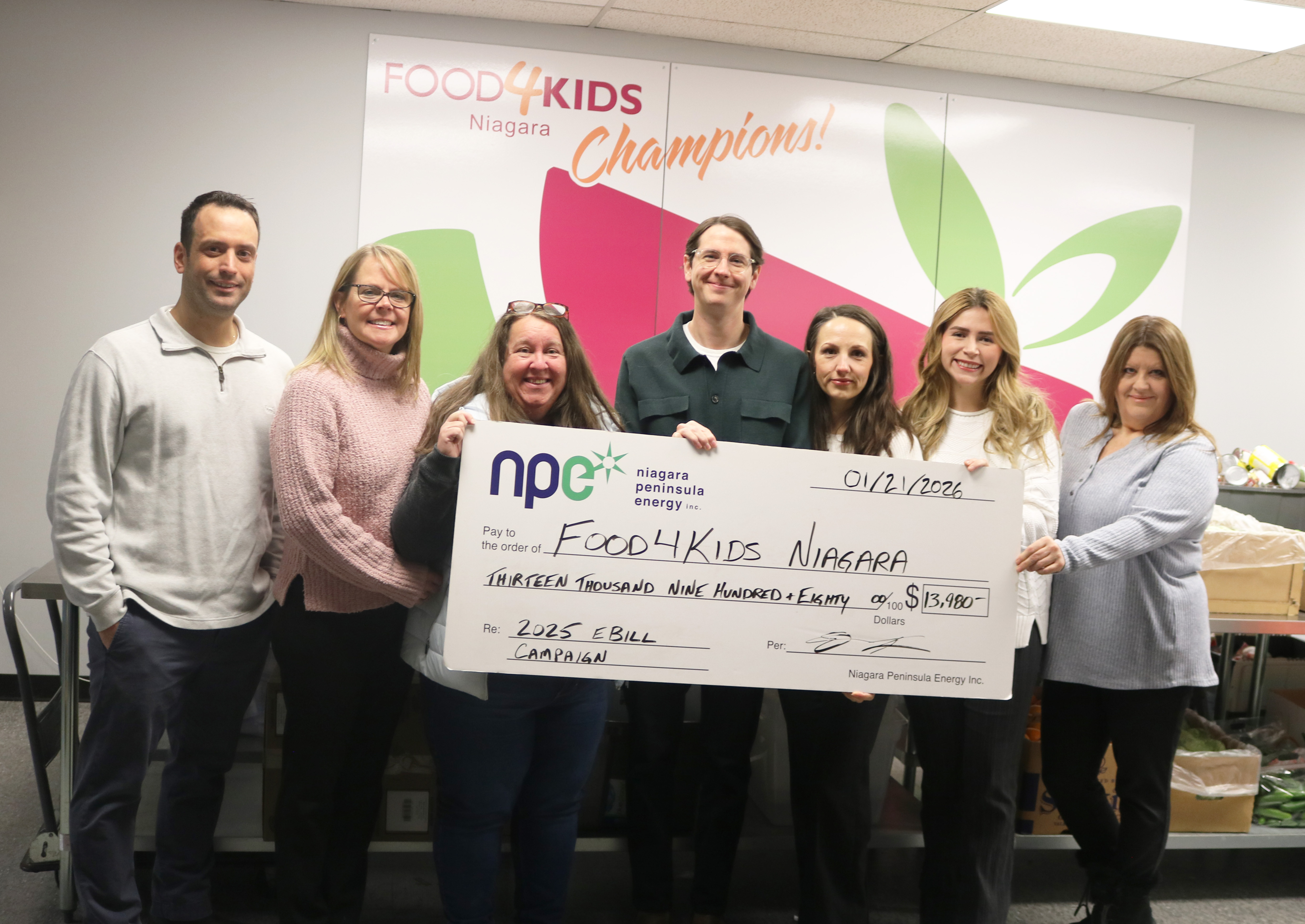 A group of NPEI staff stand with Food4Kids Niagara staff, presenting a cheque for the NPEI eBill Campaign