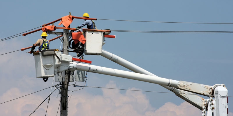 Powerline Technicians working on a pole from a bucket truck