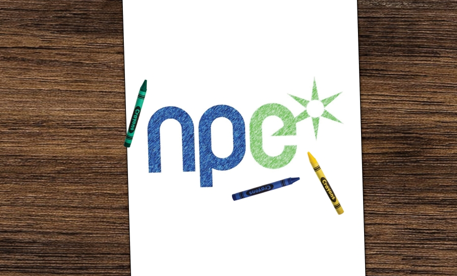 The NPEI logo drawn in crayon on a piece of paper with a few crayons laying on the paper